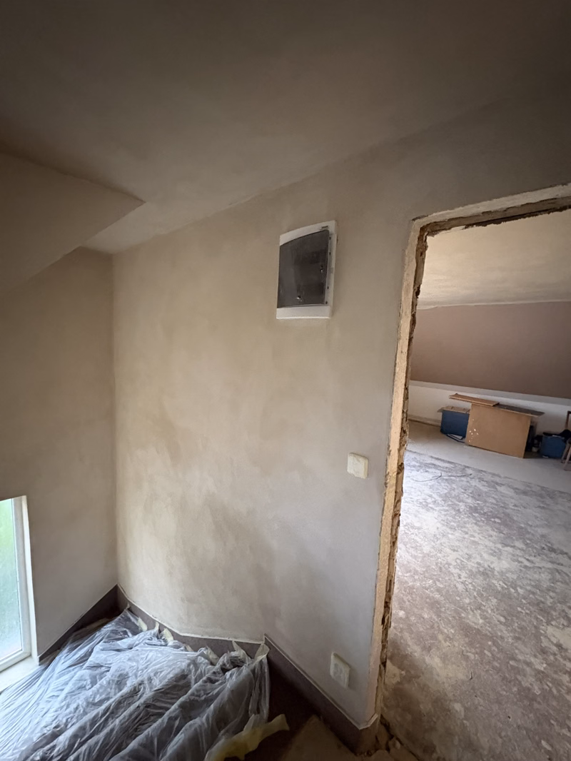 Nově omítnutá stěna s instalovanou rozvodnicí před malováním